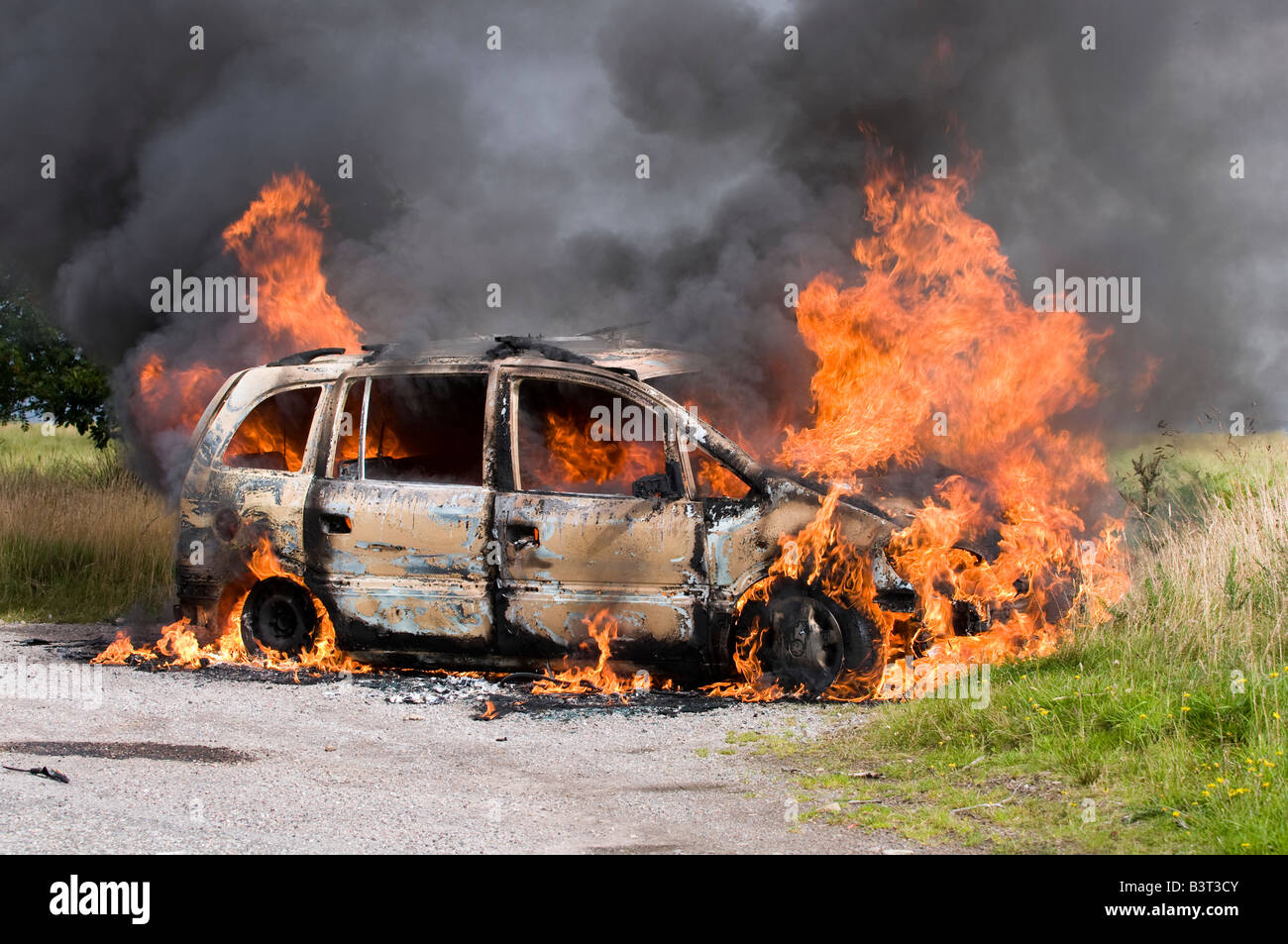 La fortuna di un fuga per il conducente di questa vettura che scoppia in fiamme in una remota strada rurale in Scozia. Foto Stock