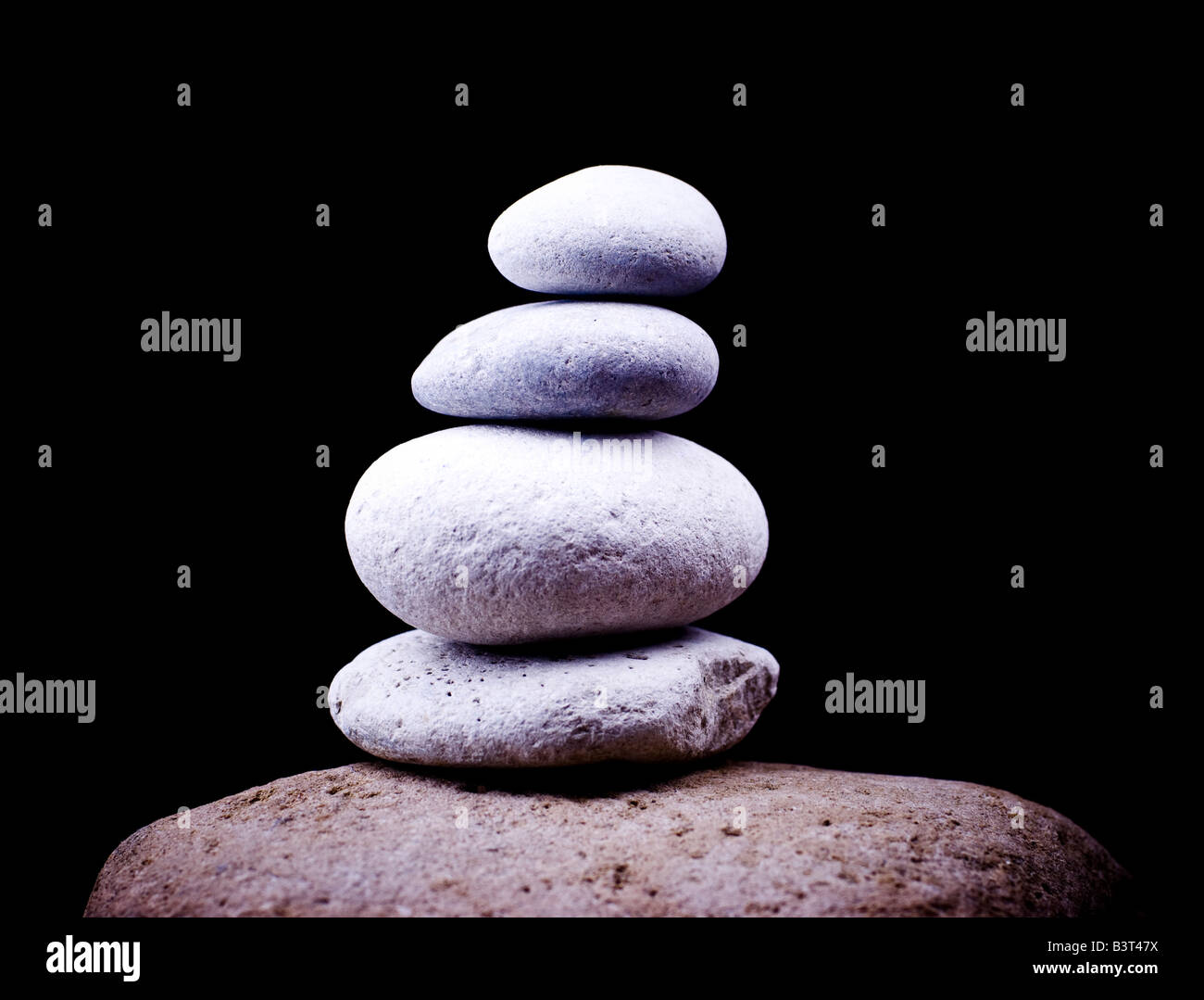 Un equilibrio di ciottoli su big stone Foto Stock