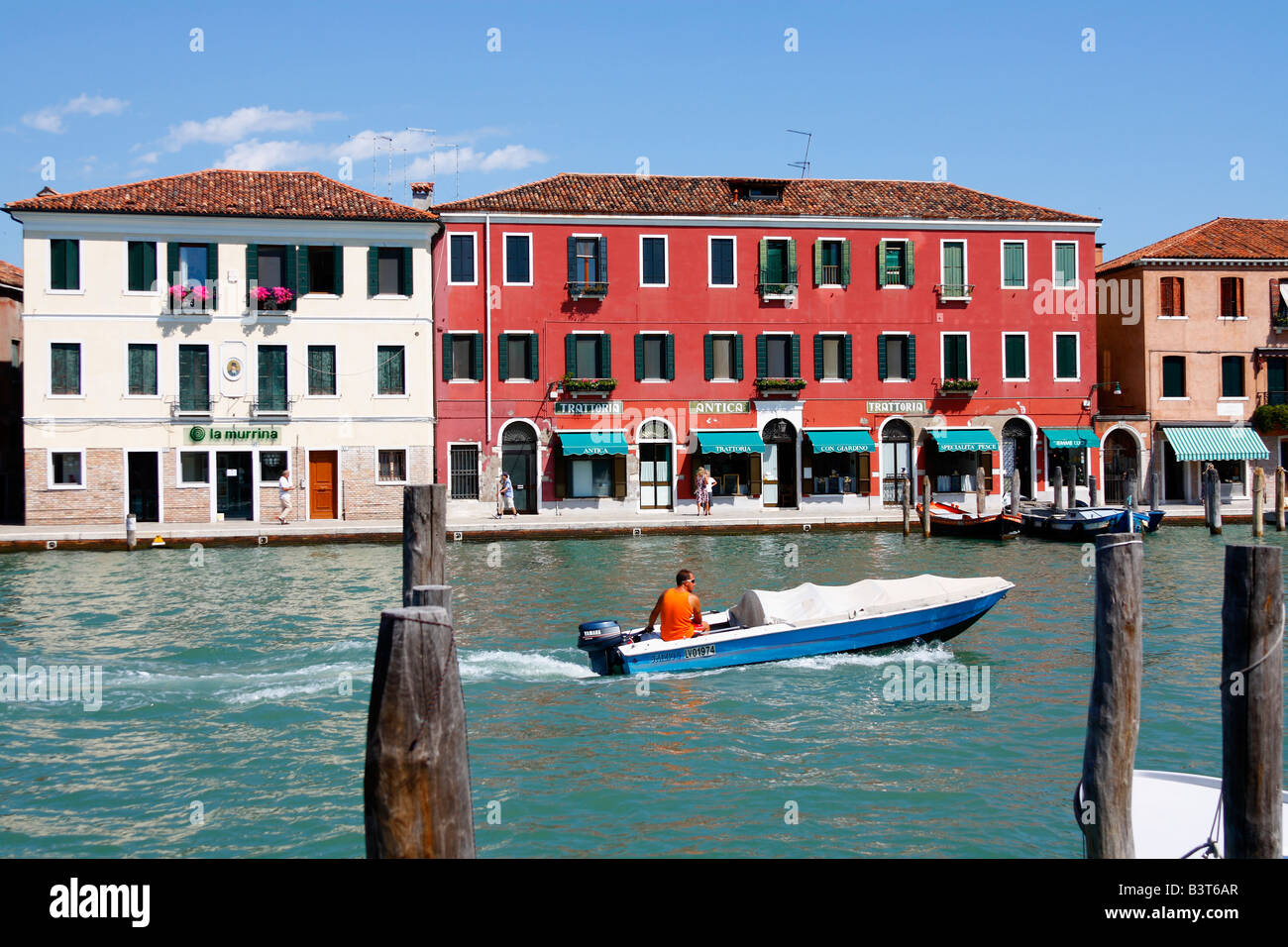 L uomo è il viaggio in barca sul canale / canale lungo con le case colorate di Murano. Venezia (Venezia), Italia, Agosto 2008 Foto Stock
