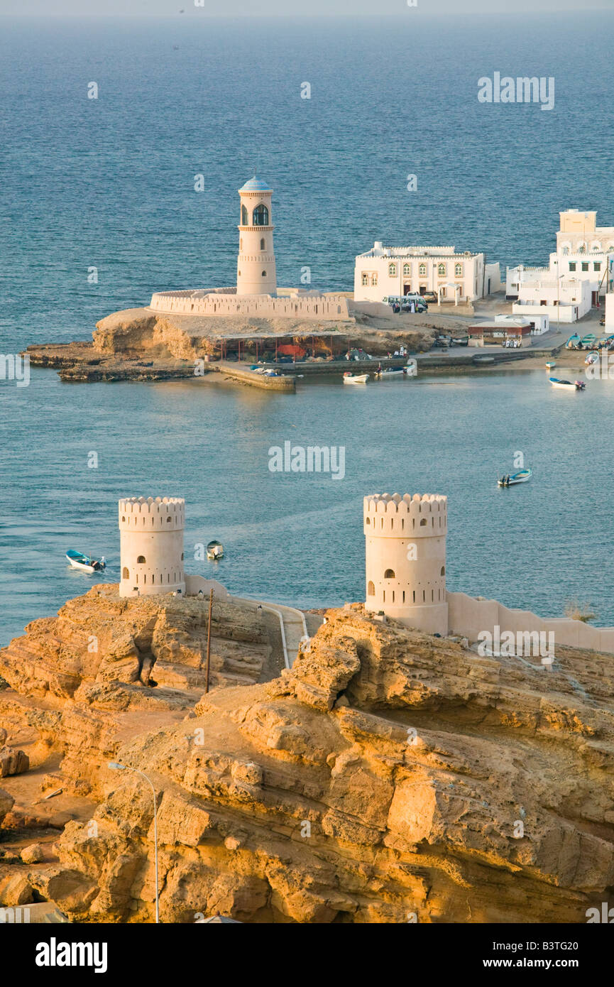 Oman, Sharqiya Regione, Sur. Torri di Al Ayajh Fort / Sur Bay / tardo pomeriggio Foto Stock