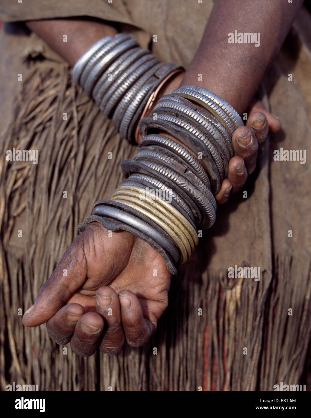 Tanzania Tanzania settentrionale, Manyara. Decorazione di numerose ferro, ottone, rame e bracciali in pelle indossato da una donna Datoga. Durante il canto e la danza, ella si sfregano tra di loro per tenere il ritmo. Il suo abito tradizionale include un splendidamente la concia della pelle vestito abbellito con perline. Il Datoga (noto ai loro vicini Masai come Mang'ati e al Iraqw come Babaraig) vivono nel nord della Tanzania e sono principalmente i pastori. Foto Stock