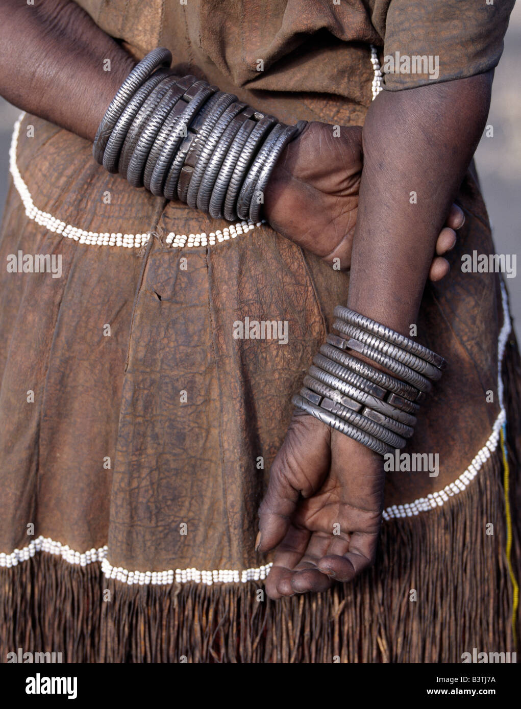 Tanzania Tanzania settentrionale, Manyara. I numerosi decorato braccialetti di ferro indossato da una donna Datoga. Durante il canto e la danza, ella si sfregano tra di loro per tenere il ritmo. Il suo abito tradizionale include un splendidamente la concia della pelle vestito abbellito con perline. Il Datoga (noto ai loro vicini Masai come Mang'ati e al Iraqw come Babaraig) vivono nel nord della Tanzania e sono principalmente i pastori. Foto Stock