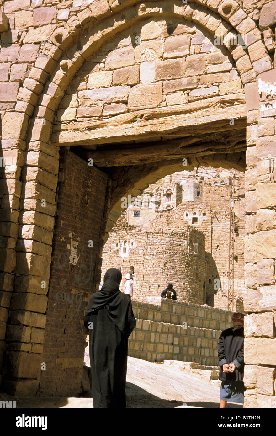 Asia, Yemen, Thilla. Donna coperta passando attraverso la porta. Foto Stock