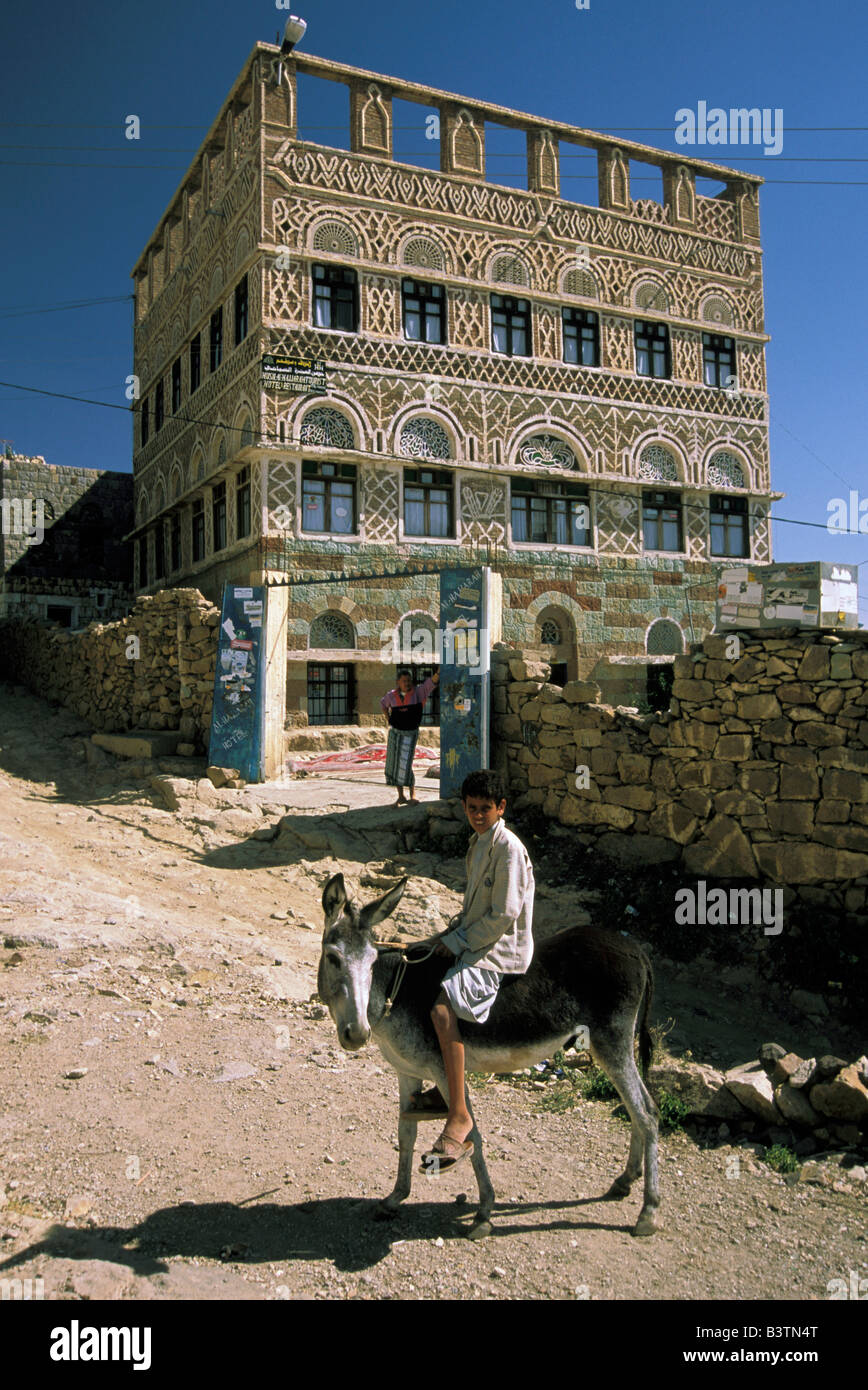 Asia, Yemen, Al Hajjara. Mutiir su donkey di fronte al Hajjara Hotel. Foto Stock