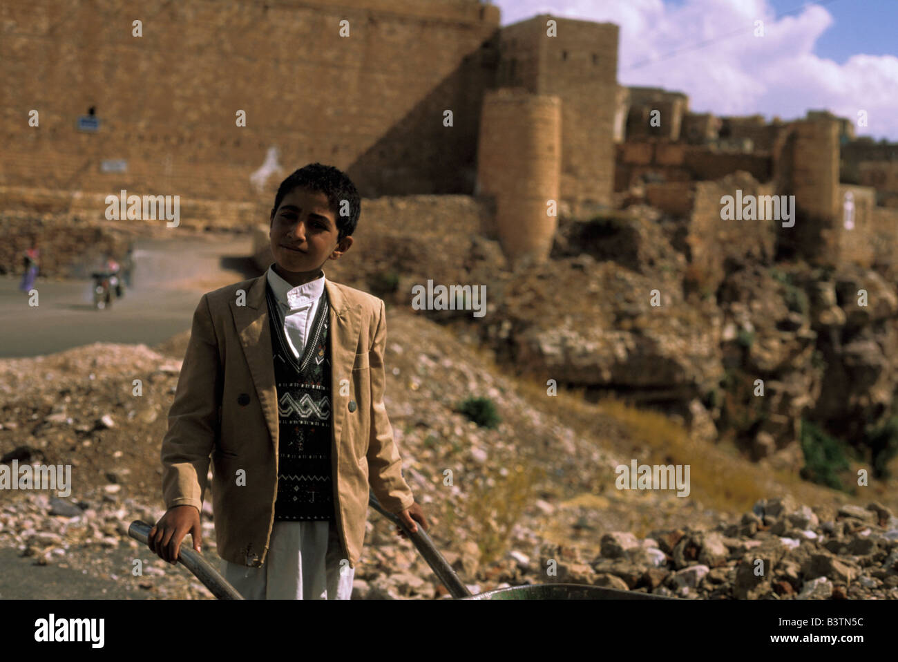 Asia, Yemen, Kawkaban. Ragazzo con cilindretto della ruota. Foto Stock