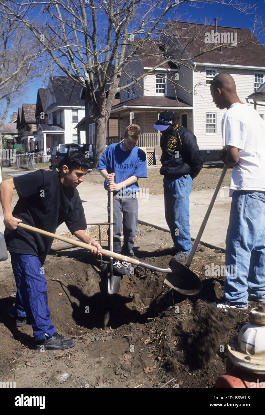 Habitat for Humanity lavoratori preparare la linea di acqua per la casa, scavare vicino marciapiede, Cleveland, Ohio usa i volontari della carità comunità Foto Stock