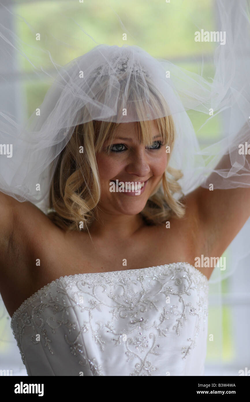 Una sposa tenendo alto il suo velo Foto Stock