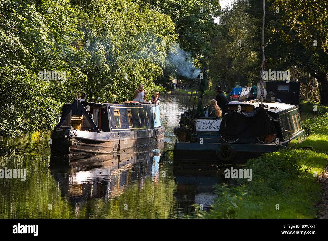 Barca stretta passando un ormeggio sul Grand Union Canal at Harefield in West London REGNO UNITO Foto Stock