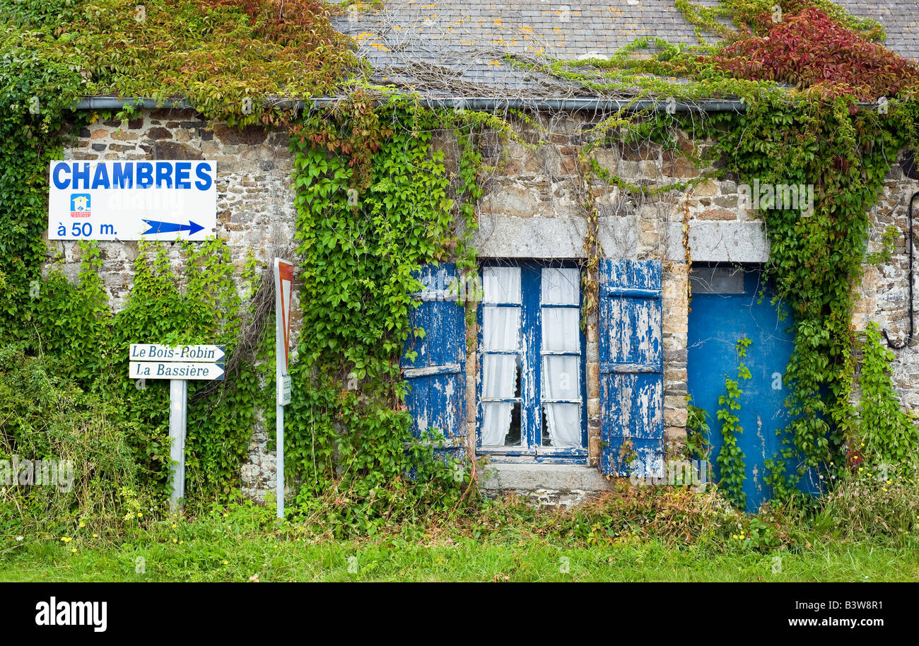 Bed and breakfast e segnaletica stradale e la vecchia casa con persiane blu e sportello Bretagna Francia Foto Stock