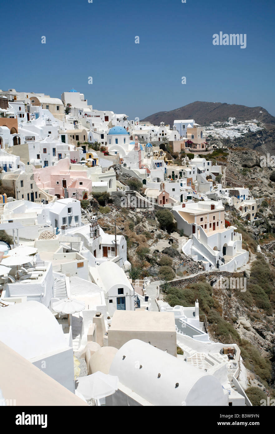 Una vista del villaggio di Oia Santorini con le sue numerose chiese che sono diventati iconica di isole greche Foto Stock