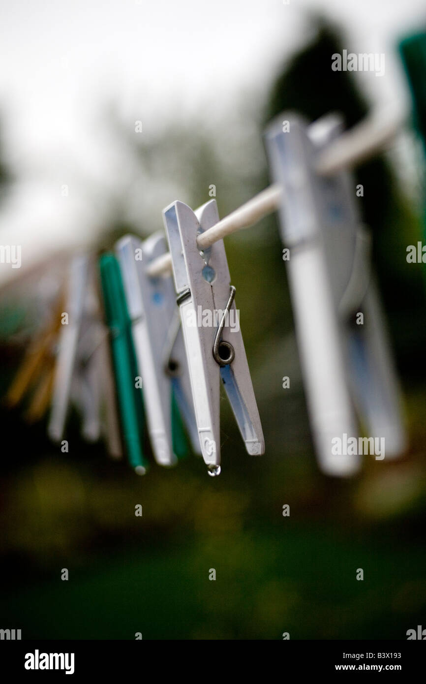 Vestiti bagnati pioli su un lavaggio wet linea. Foto Stock