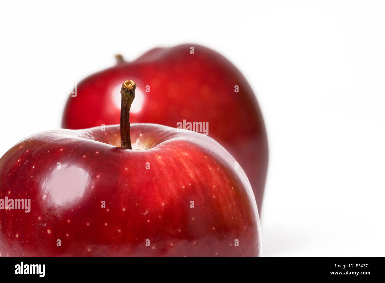 Due mele rosse vicino davanti a uno sfondo chiaro Foto Stock