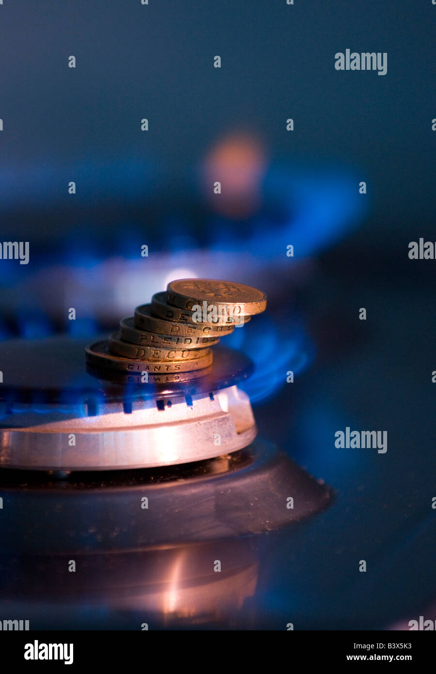 Pila di monete su un piano cottura a gas Foto Stock