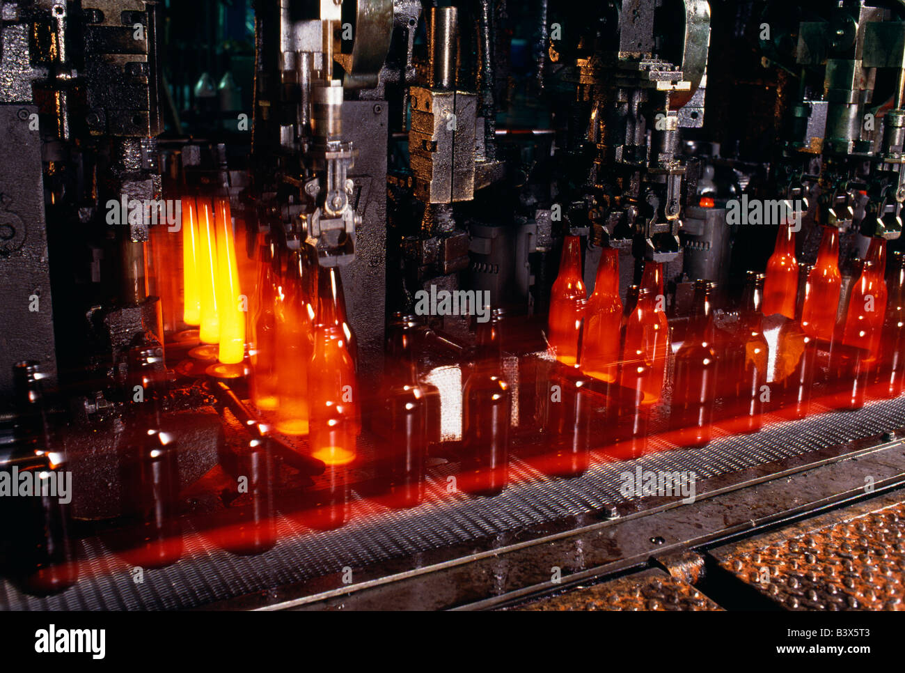 Vista ravvicinata della linea di assemblaggio per la fabbricazione di bottiglie in vetro Foto Stock