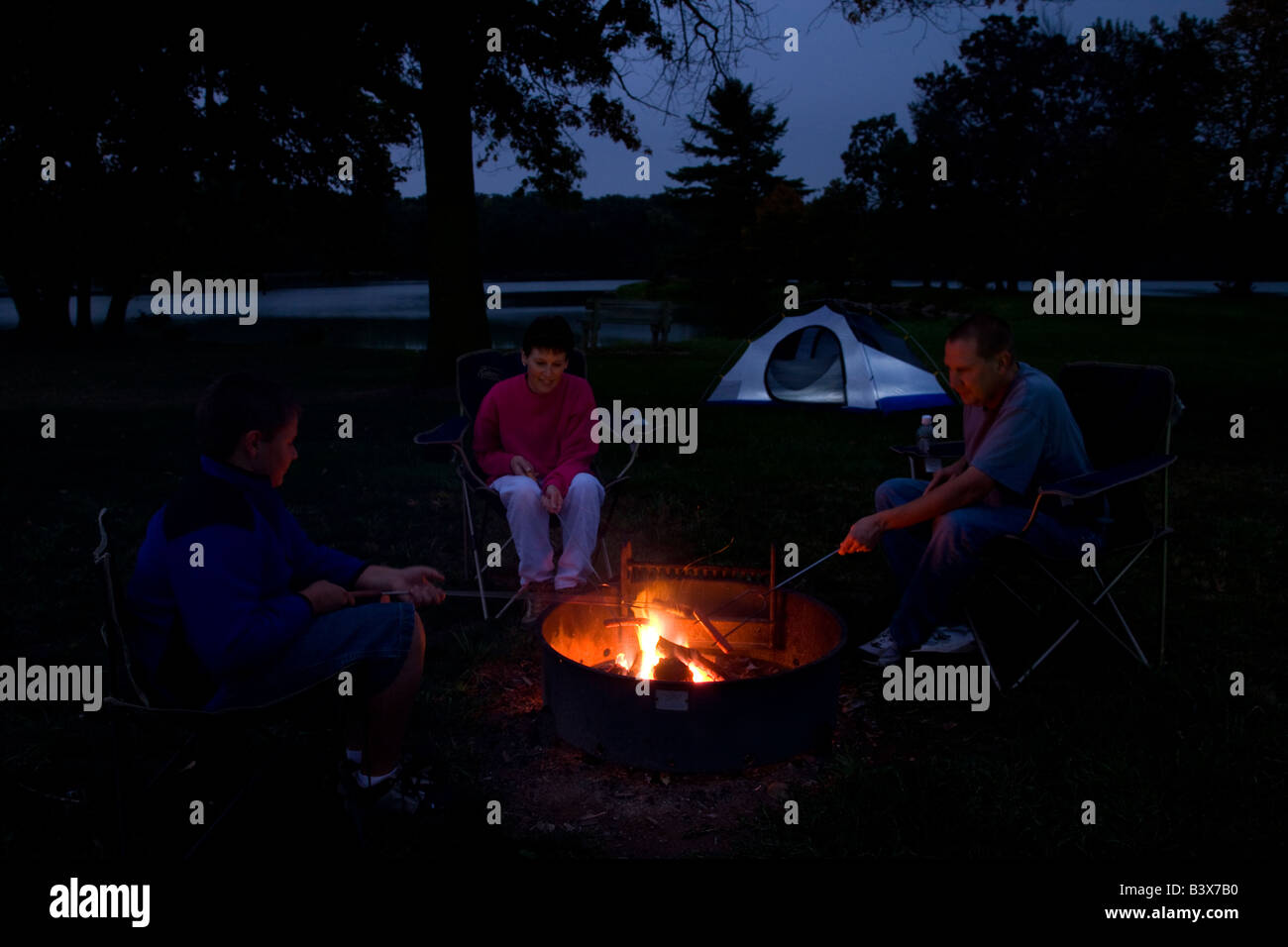 Famiglia intorno al falò al campeggio lago Hendricks County Park, Howard County, Iowa Foto Stock