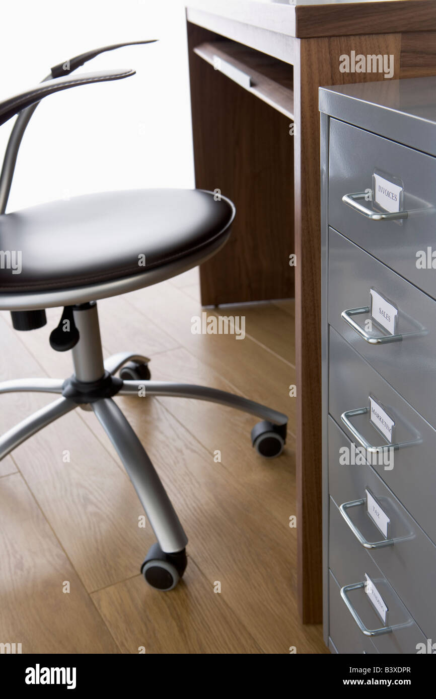 Sedia vuota e scrivania con Filing cabinet Foto Stock