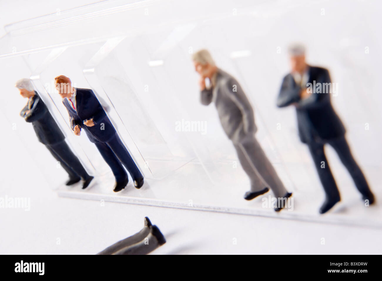 Fila di imprenditore figurine, con una caduta fuori linea Foto Stock