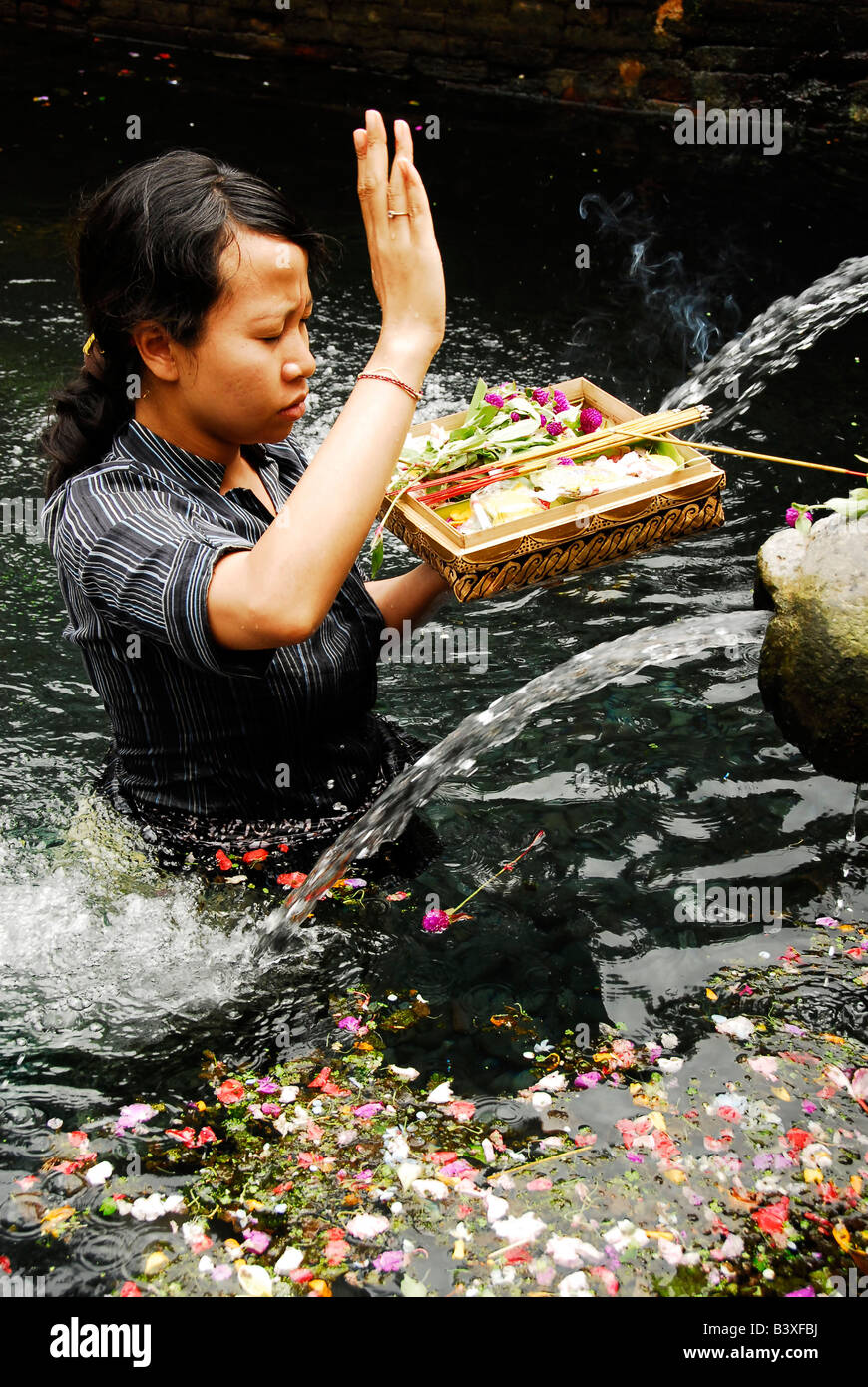 Signora pregando nel santo molle di Tirta Empul, Pura Tirta Empul(tempio), Tampak Siring , area di Ubud , bali , Indonesia Foto Stock