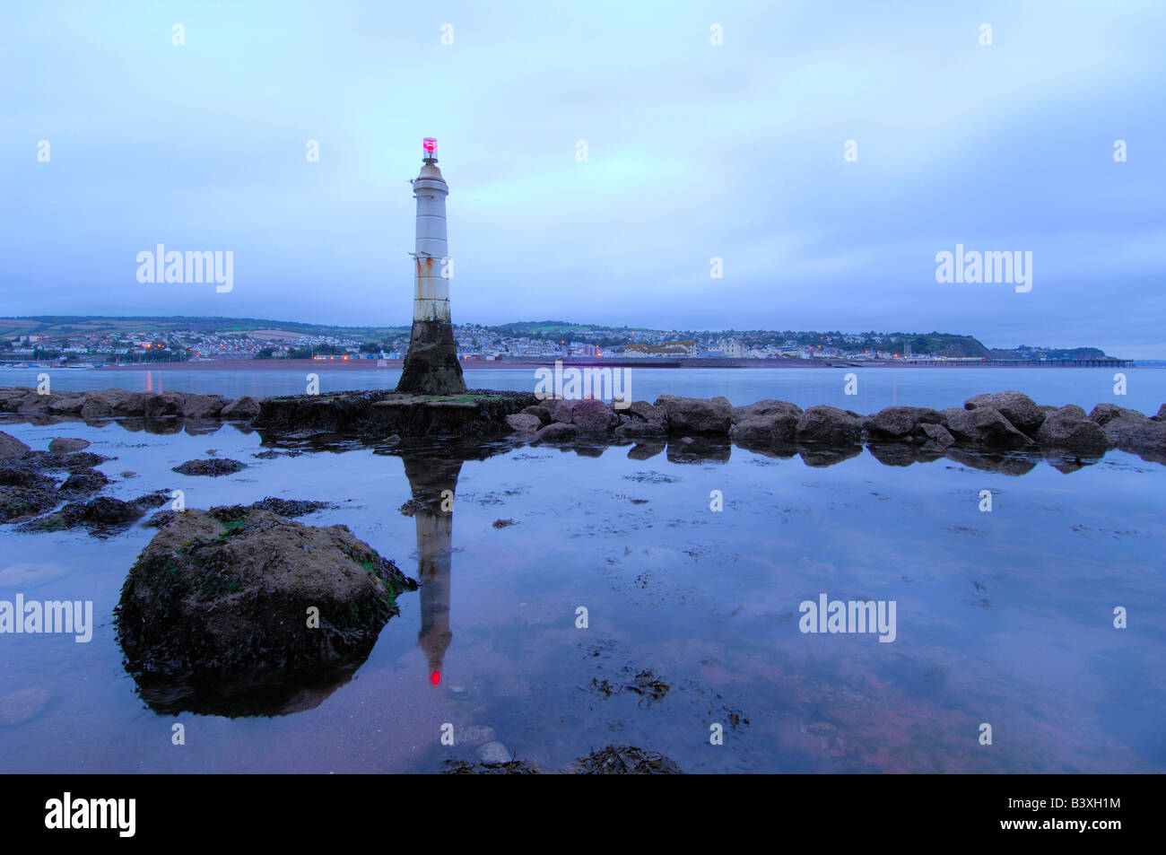 Appena prima dell'alba sulla spiaggia Shaldon sotto il Ness nel South Devon con il frangiflutti e il faro in primo piano Foto Stock