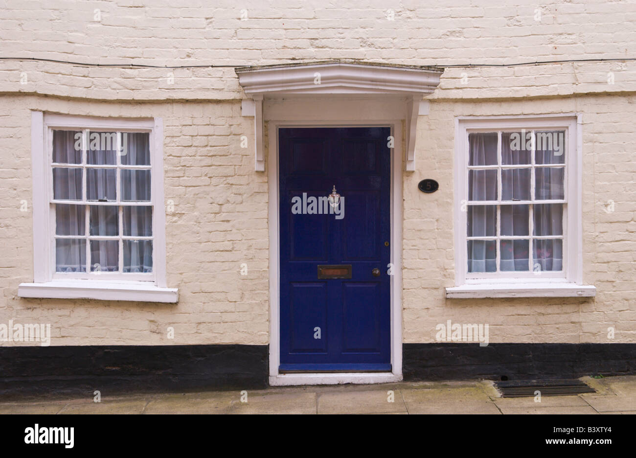 Blu porta anteriore con telaio bianco e portico di bungalow a schiera a Ludlow Shropshire England Regno Unito Foto Stock