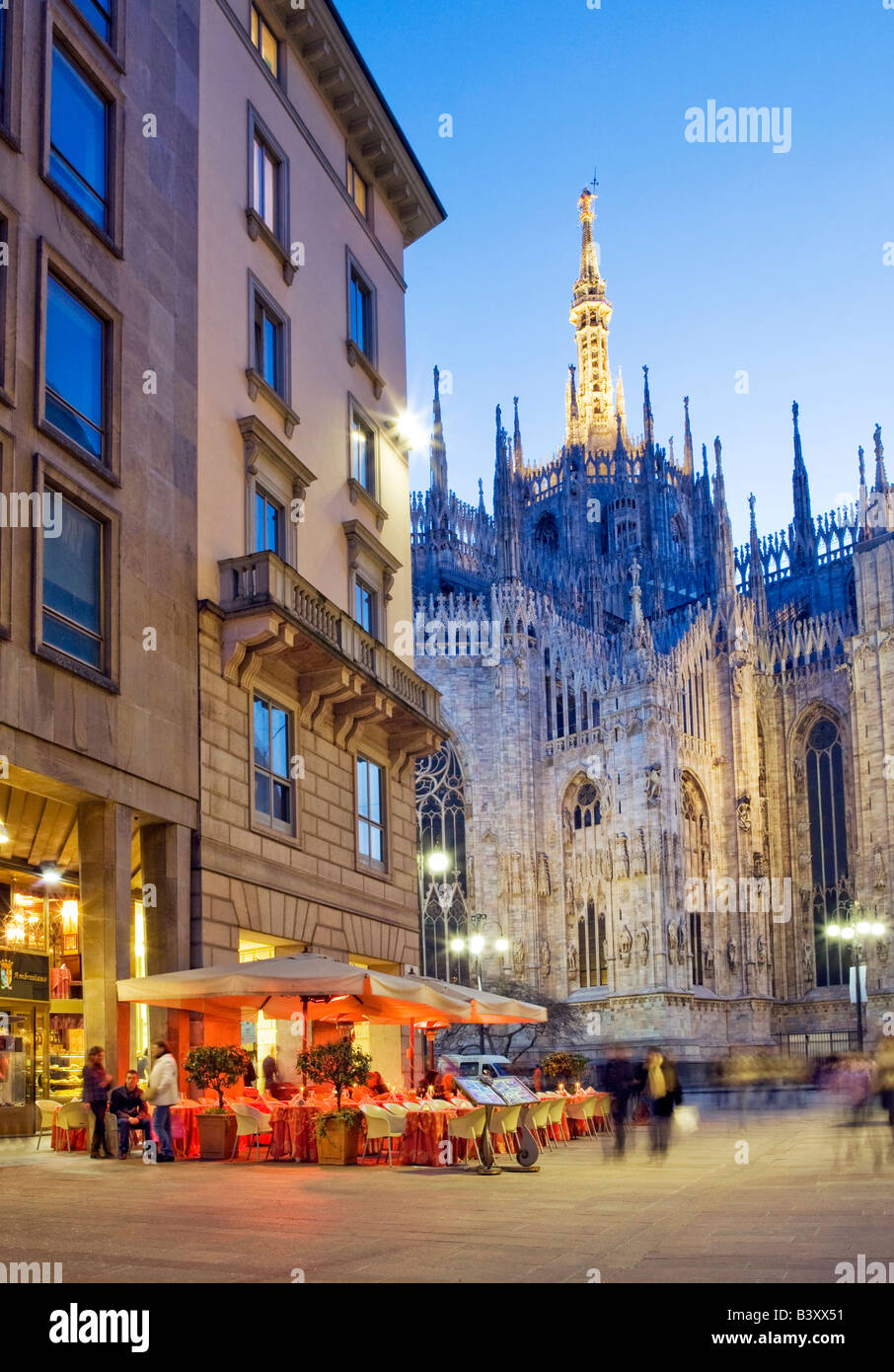 Persone a pranzare in un cafe' all'aperto e la gente a fare shopping. Piazza del Duomo di Milano, Italia. Foto Stock
