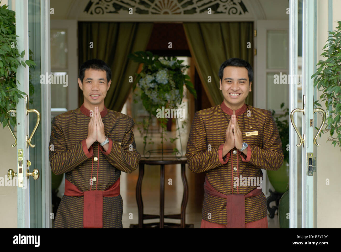 Il sorriso di benvenuto Sawasdee Welcome saluto fiori esotici, ala Authours Oriental Hotel Bangkok autori ala Travel Asia portiere Foto Stock