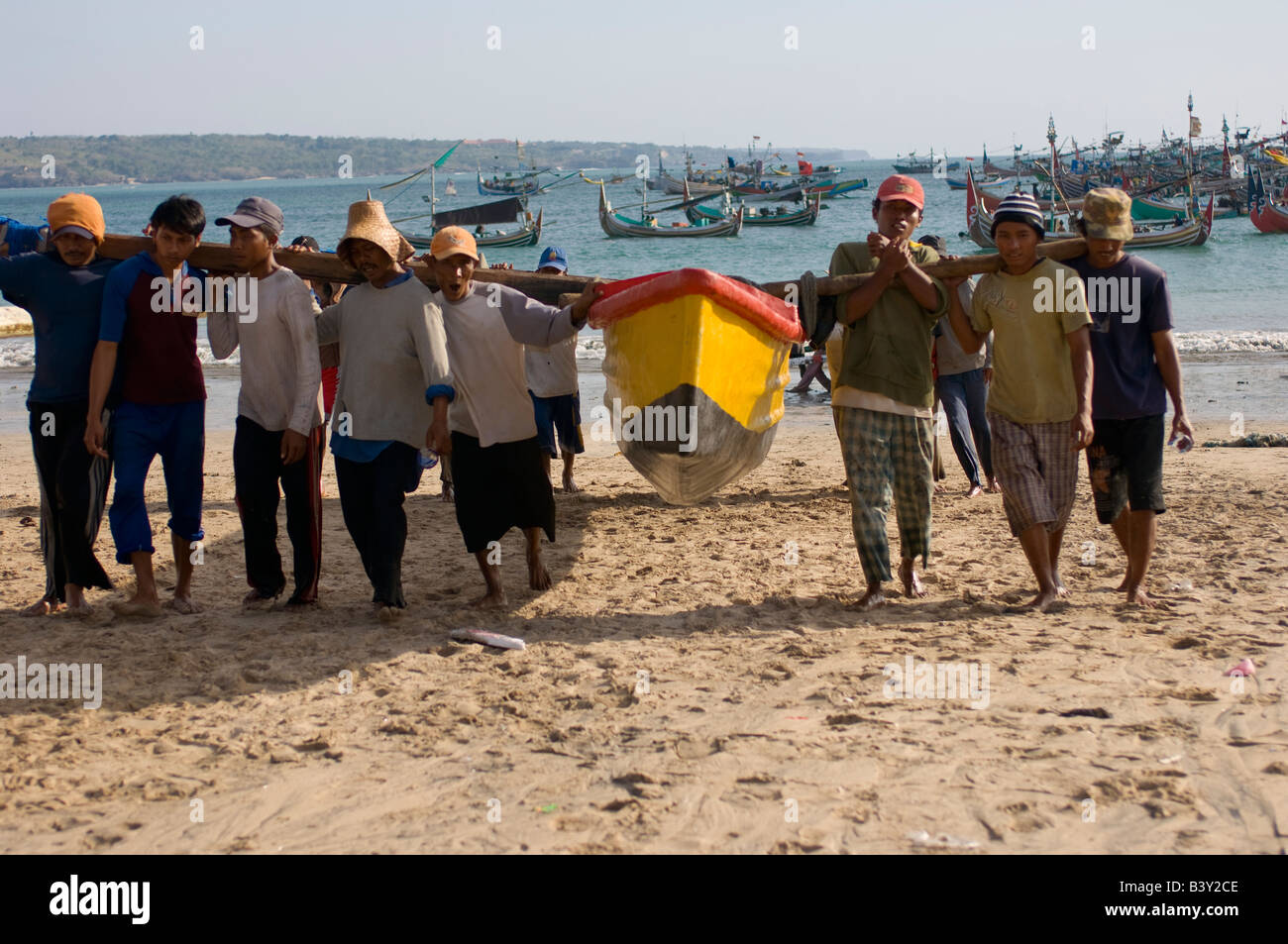 I pescatori portano le loro barche dall'acqua s edge dopo una giornata di pesca Foto Stock