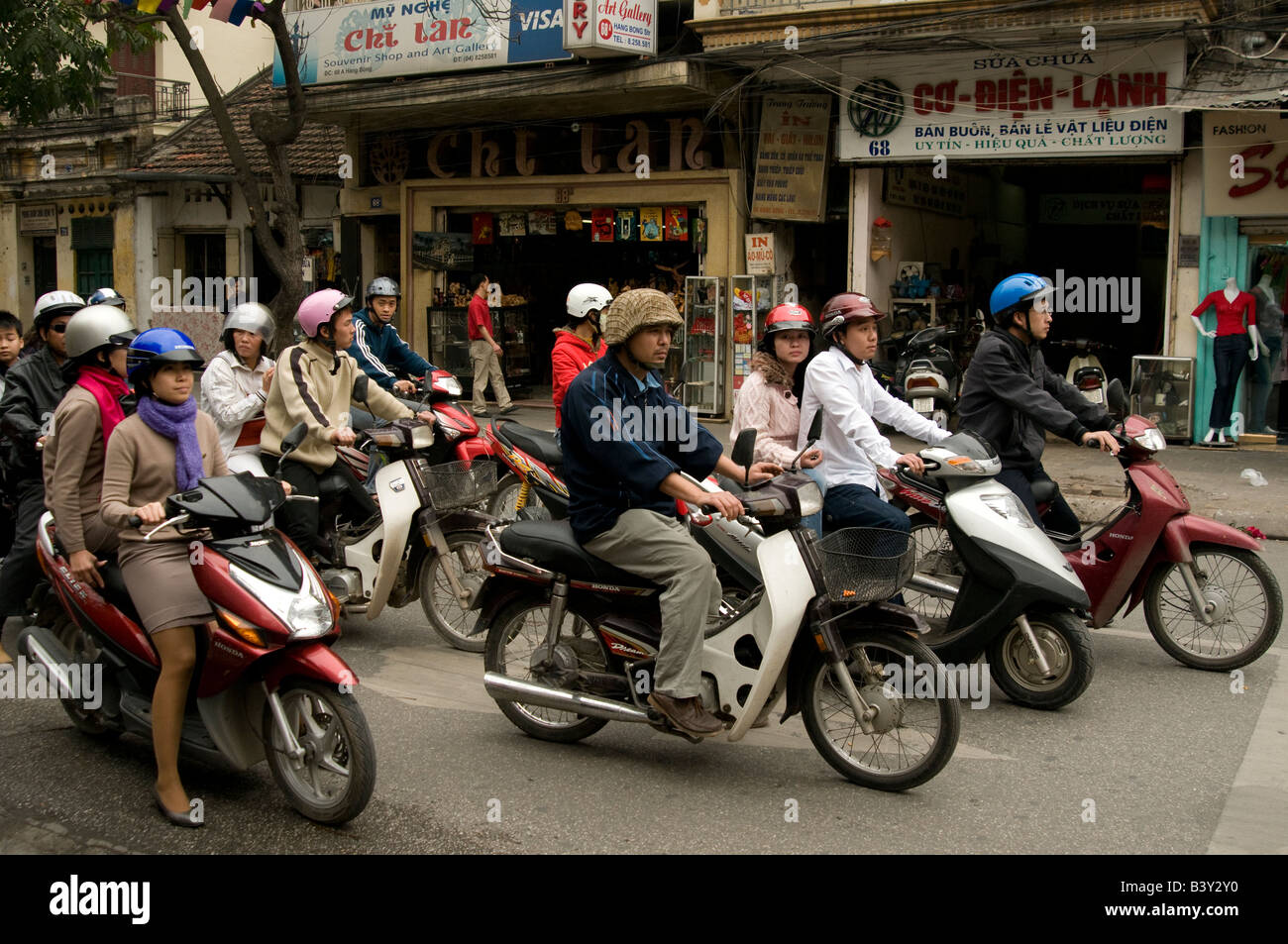 Una linea di ciclomotori e scooter attendere al semaforo in Hanoi Vietnam Foto Stock