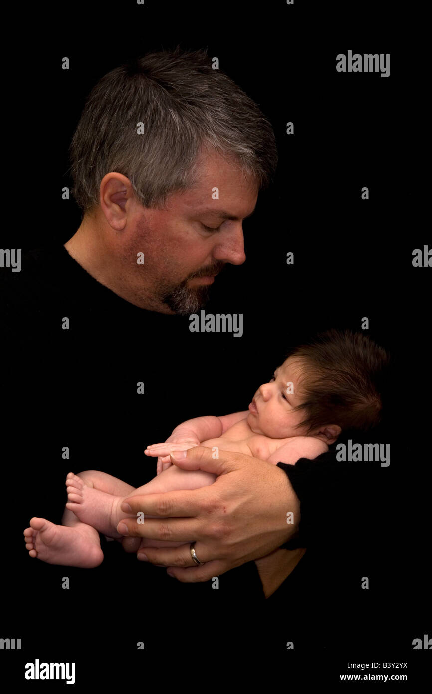 Padre guardando verso il basso a 1 mese vecchio figlio Foto Stock