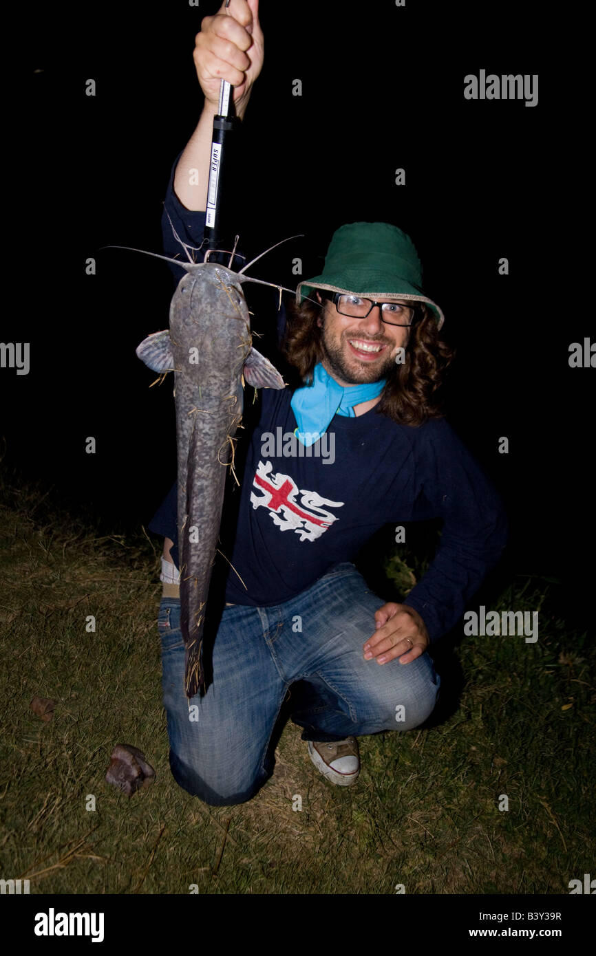Pescatore con un grande pesce gatto barbell catturato di notte quando si nutrono. Kafue Zambia Africa Foto Stock