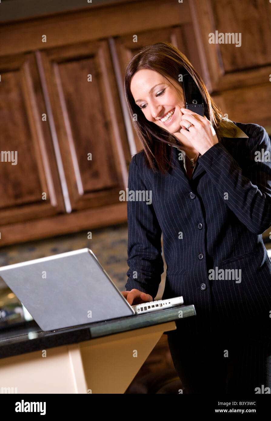Imprenditrice utilizzando un telefono cellulare e un pc portatile Foto Stock