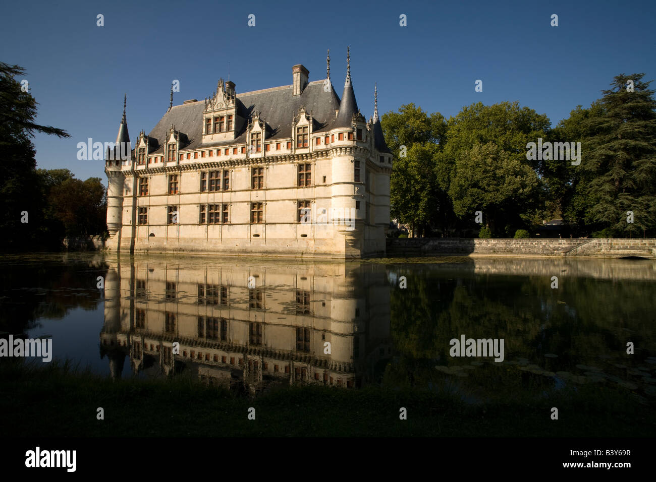 Facciata sud del castello rinascimentale d'Azay-le-Rideau riflessa nel fiume Indre nel pomeriggio di sole, Valle della Loira, Franc Foto Stock