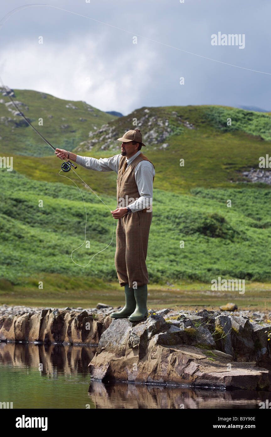 La Scozia, Ebridi Interne, Jura. Gordon Muir, stalker e ghillie a Glen Batrick Lodge Di pesca alla trota su una collina loch Foto Stock