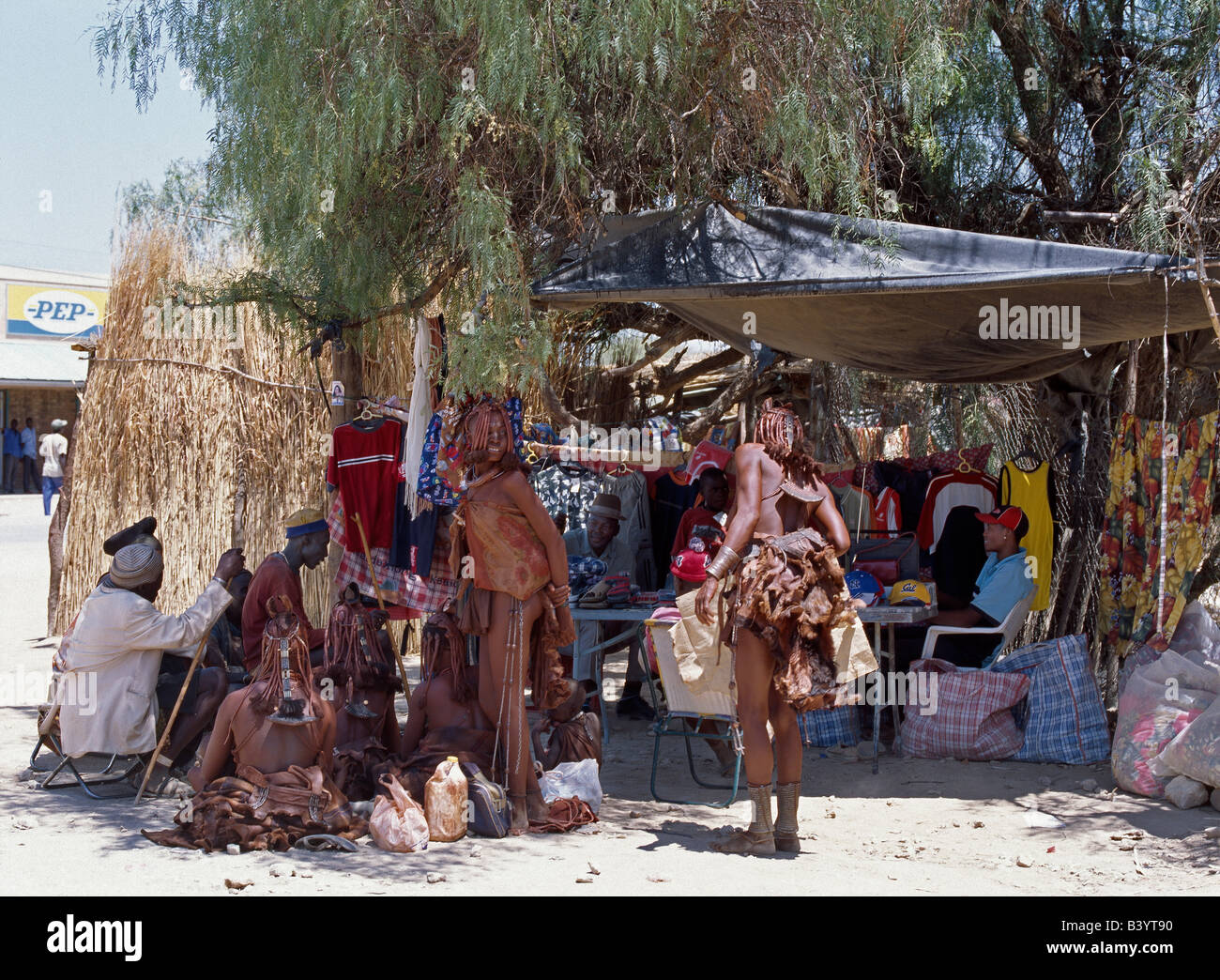 La Namibia, il Kaokoland, Opuwo. Un angolo di stallo stradale nella polvere della città di Opuwo, il principale centro di commercio Kaokoland. Il nomade popolo Himba visita questo centro regolarmente per comprare le disposizioni e a godere del 'luci luminose". Opuwo in locali Herero lingua significa 'Fine'. Foto Stock