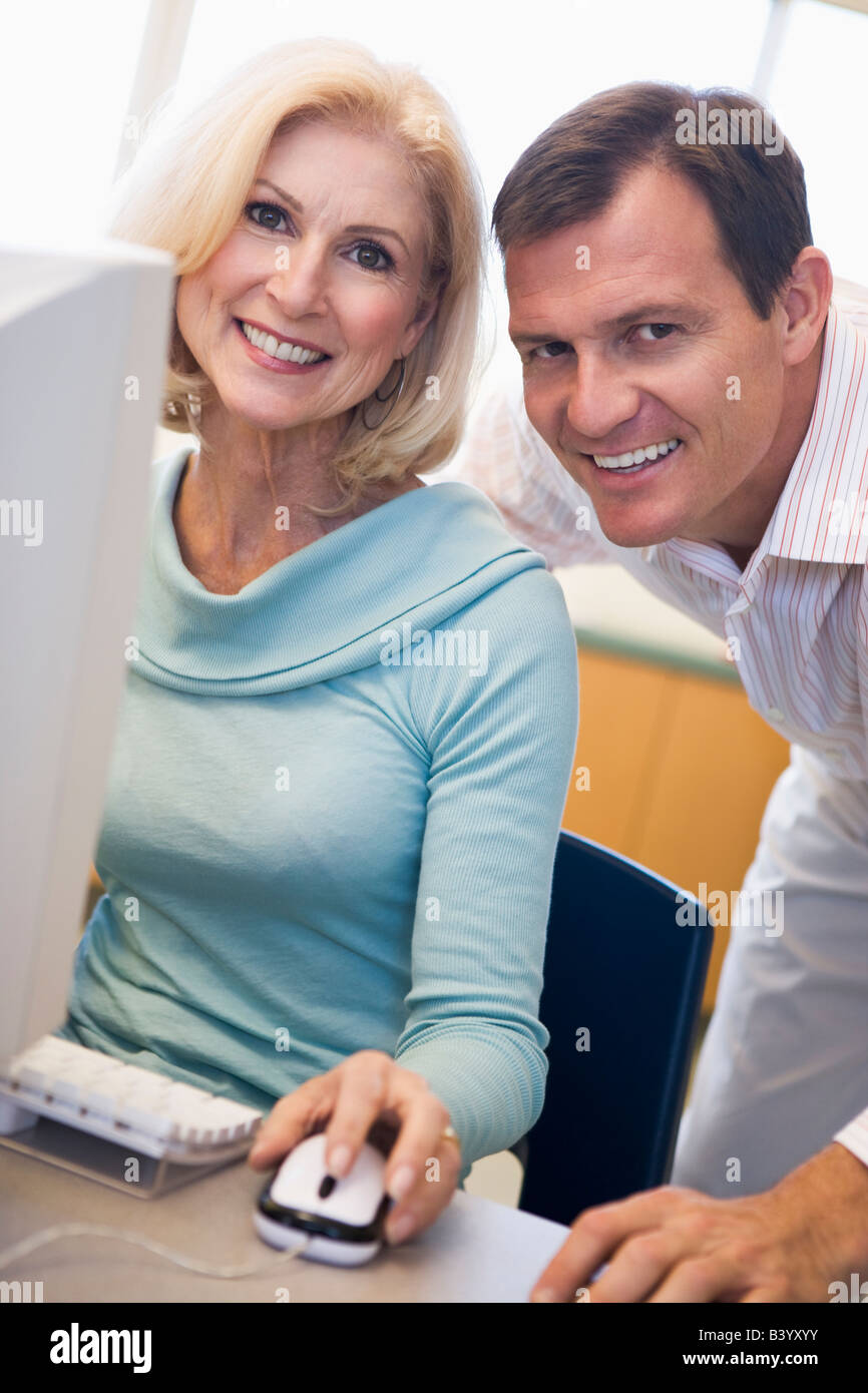 L uomo e la donna al computer sorridente (high key) Foto Stock