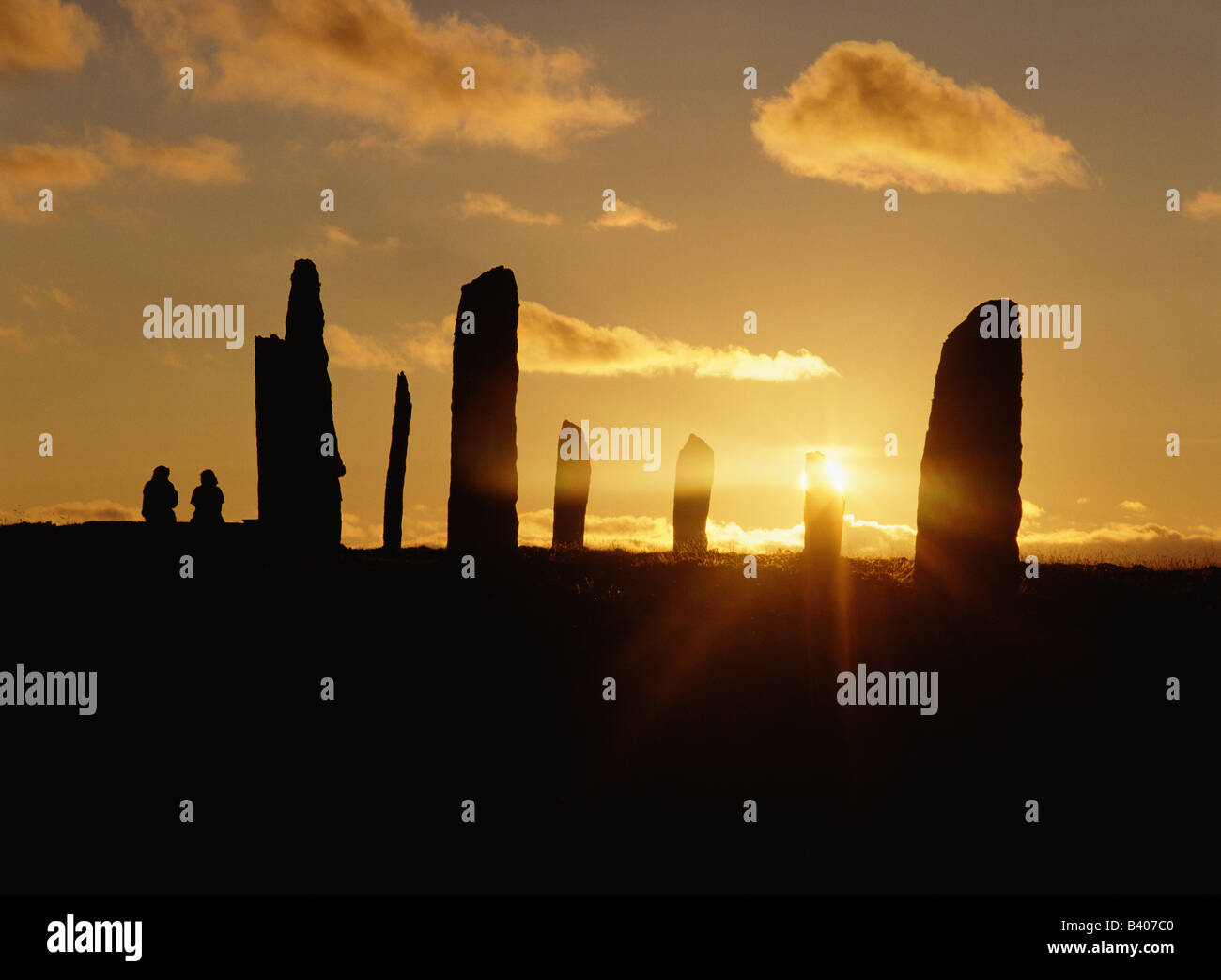 dh cerchio di pietra in piedi ANELLO DI BRODGAR ORKNEY persone seduta guardando il tramonto turisti vacanza uk bronzo età sito visita attrazione Pietre della Scozia Foto Stock