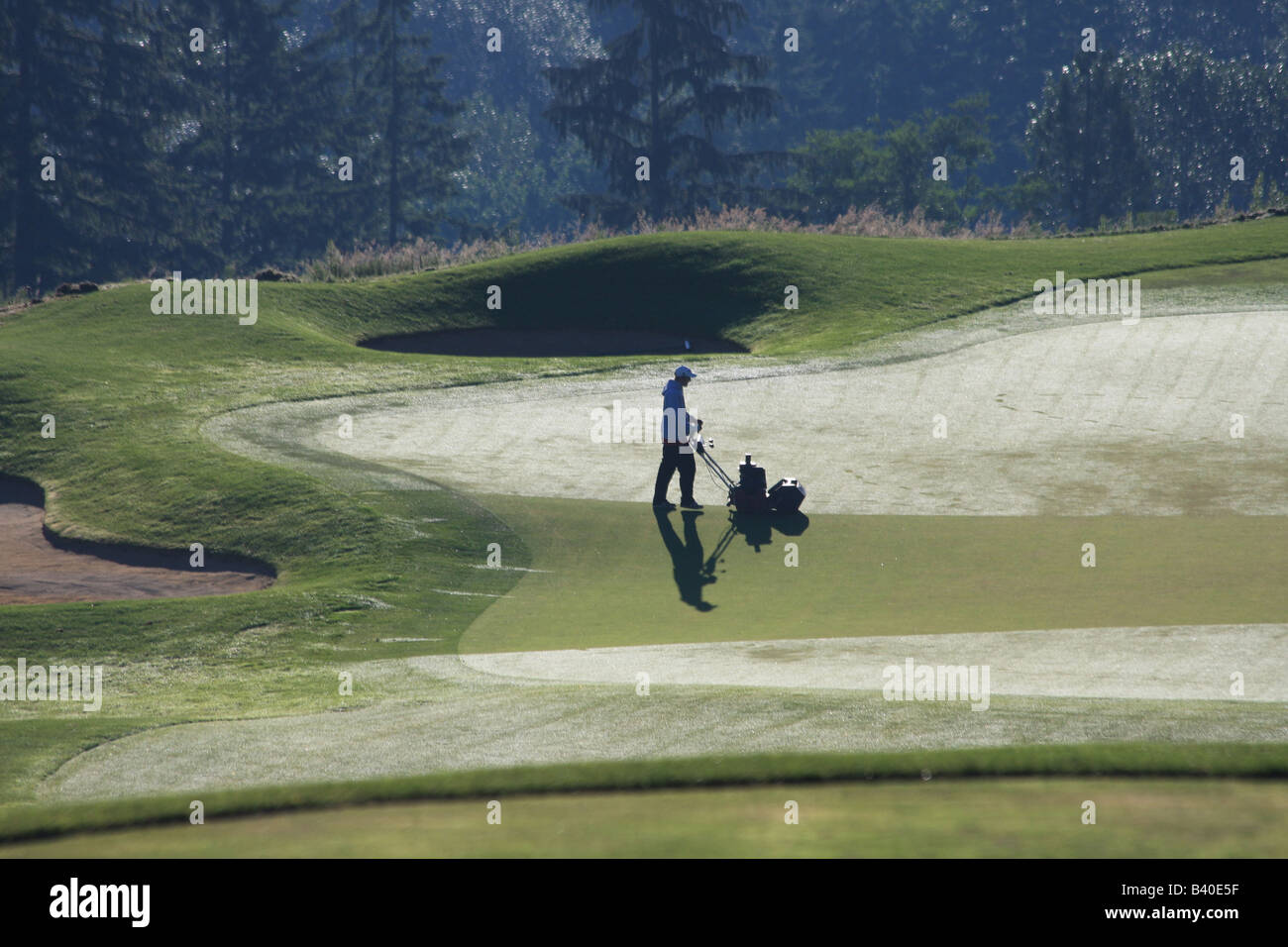 Nelle prime ore del mattino, i Verdi equipaggio preparare il Newcastle Golf Club a Newcastle, Washington, per giocare. Foto Stock