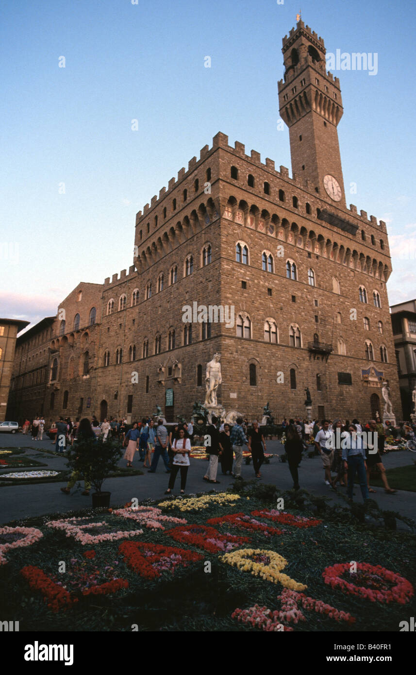 Palazzo Vecchio torreggia su una folla in Piazza della Signoria a Firenze Italia Foto Stock