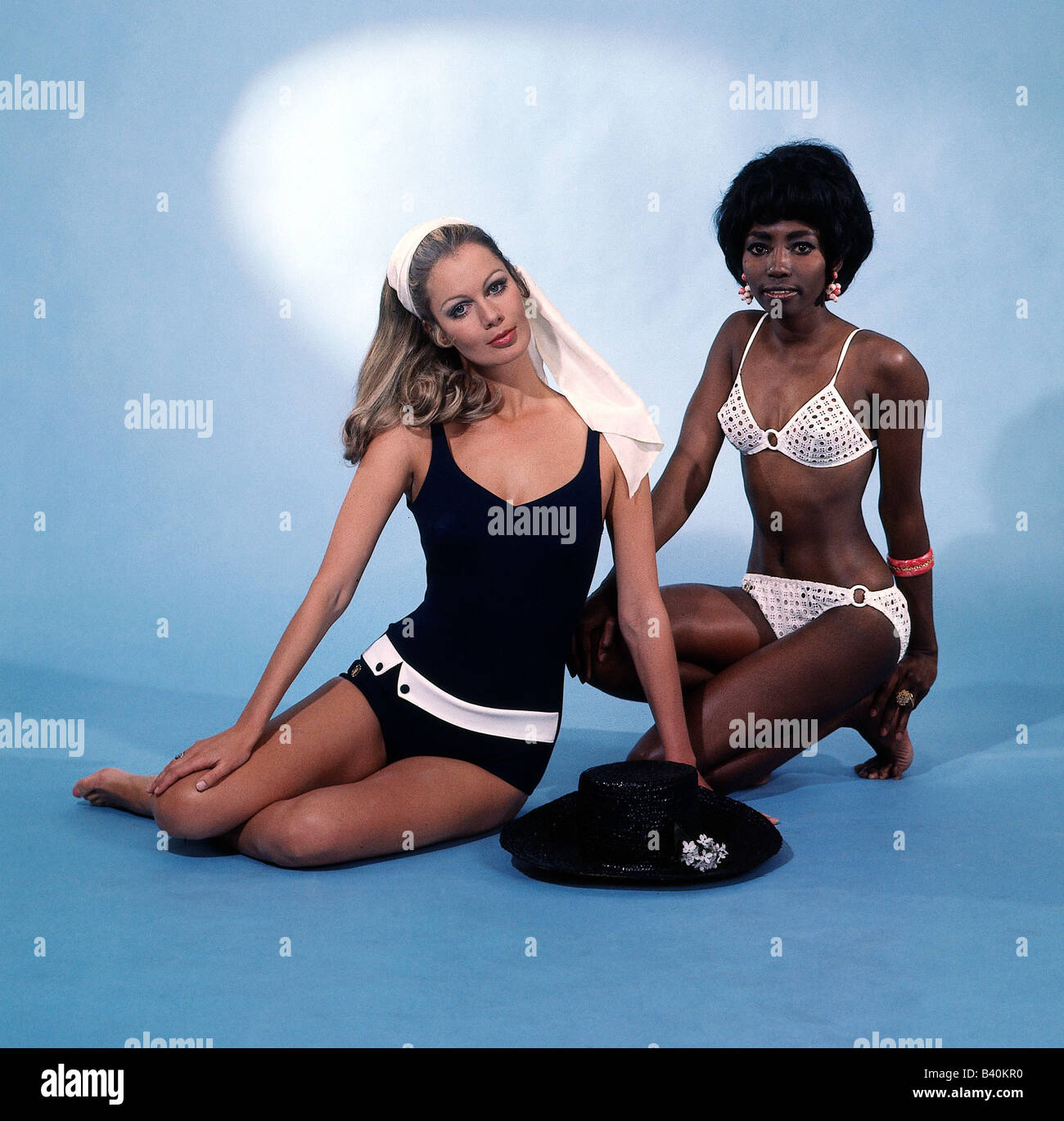 moda, due donne, a tutta lunghezza, seduto, con costume da bagno, bikini, studio, 1960s, 60s, due pezzi, un pezzo, unicolored, accessorio, sciarpa, cappello, costume da bagno, , Foto Stock