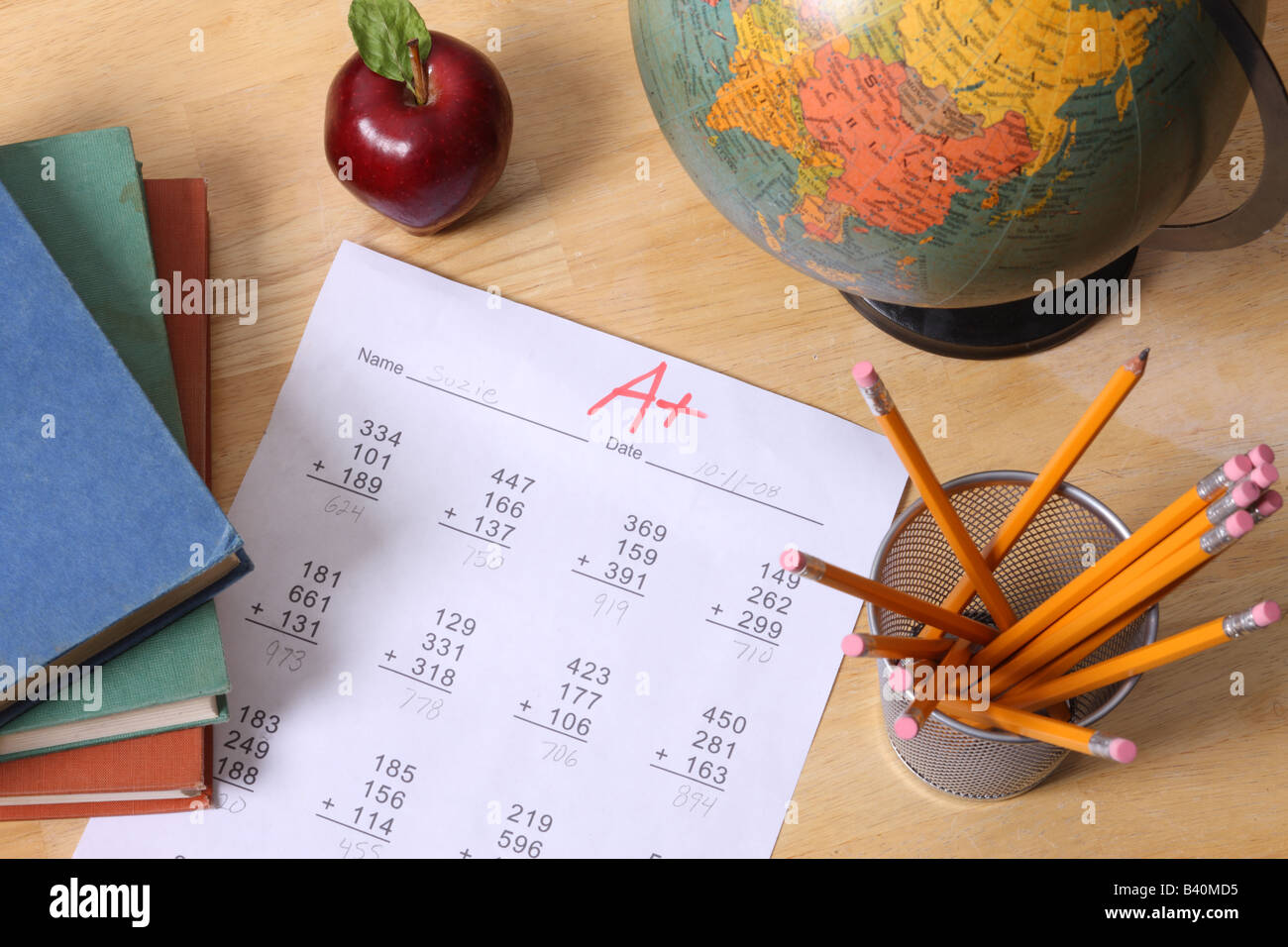 Istruzione scolastica ancora in vita con globo libri apple matite e una carta con un grado Foto Stock