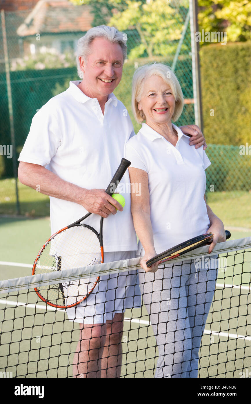 Giovane giocando a tennis e sorridente Foto Stock