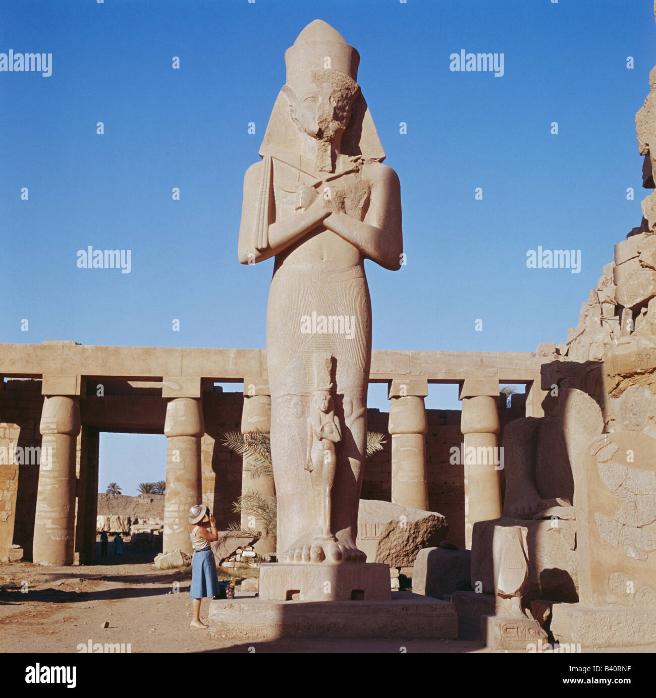 Tourist fotografare la statua colossale del Tempio di Karnak Luxor Egitto, Nord Africa Foto Stock