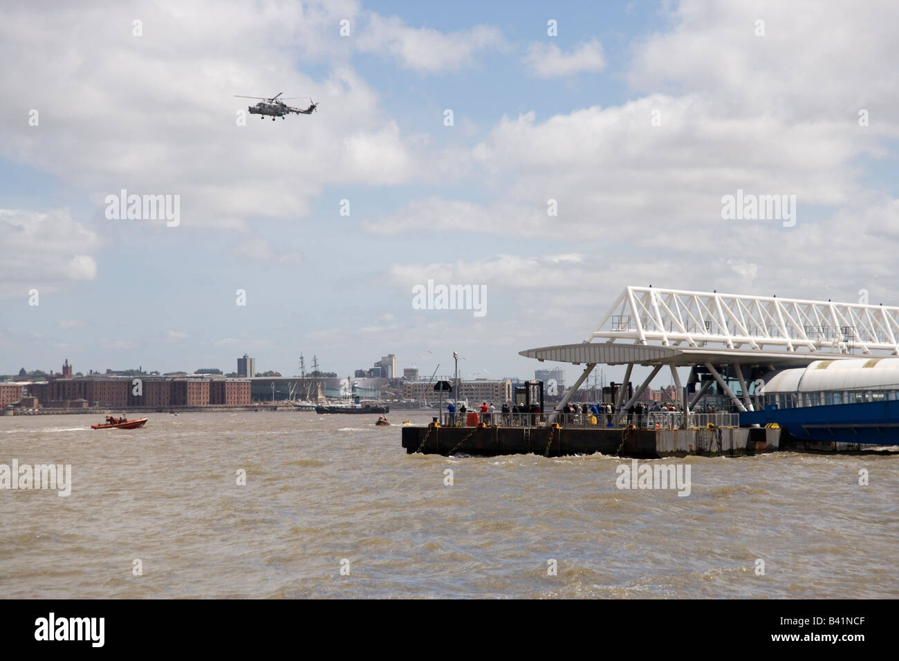 Royal Navy Lynx elicottero sorvolano Liverpool e il piede Seacombe ferry e il fiume Mersey nella Tall Ships Race parade Foto Stock