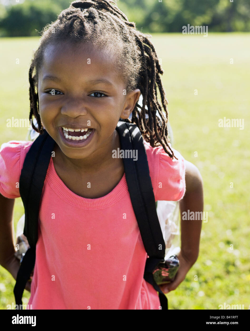 Giovane africano ragazza americana che indossa uno zaino sorridente in telecamera Foto Stock