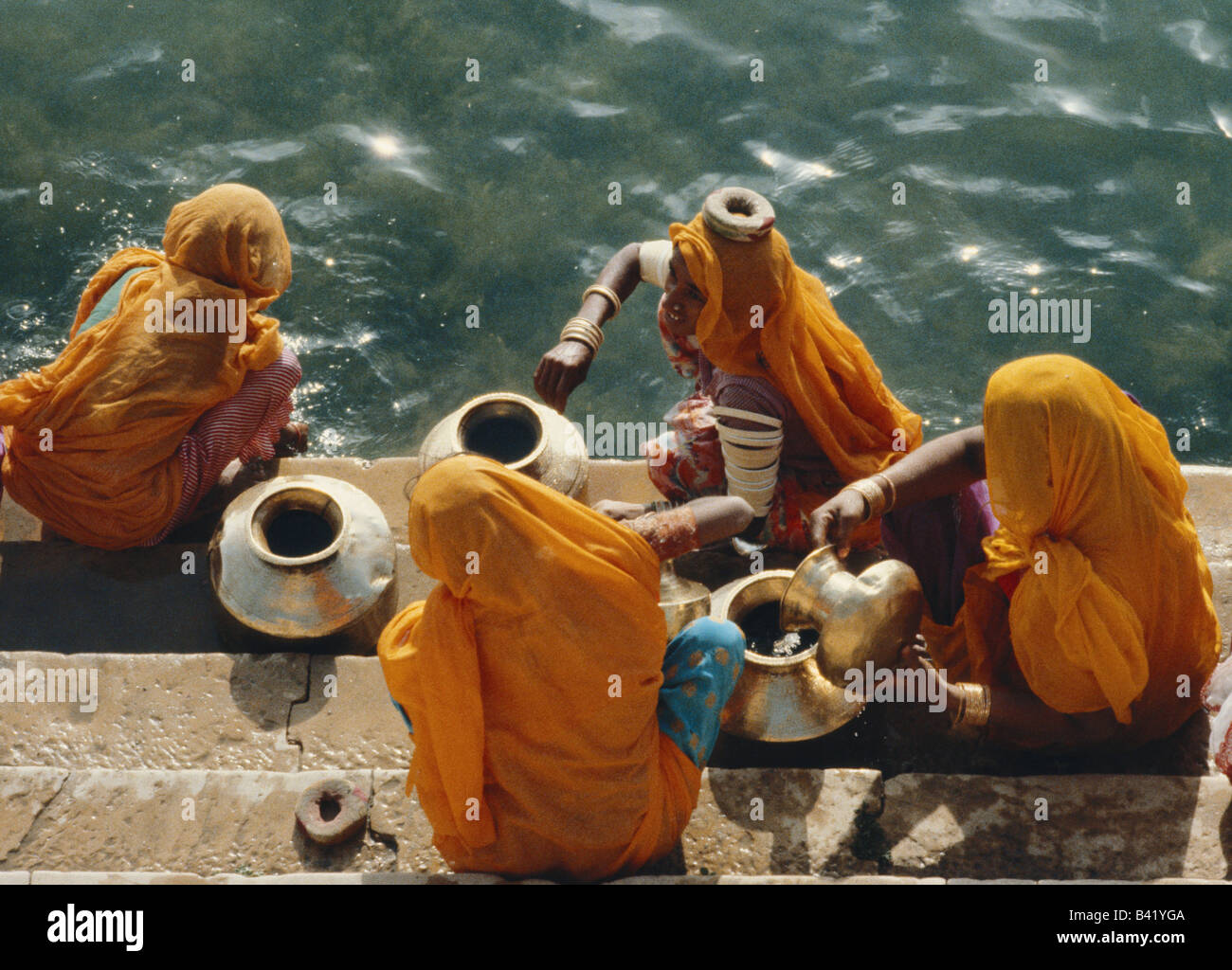 Le donne a raccogliere acqua dal lago Gadisar, Jaisalmer, Rajasthan, India Foto Stock