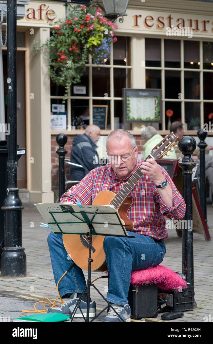 Uomo di mezza età classica suonare la chitarra acustica musicista di strada in strada al Food festival Ludlow Shropshire England Regno Unito Foto Stock