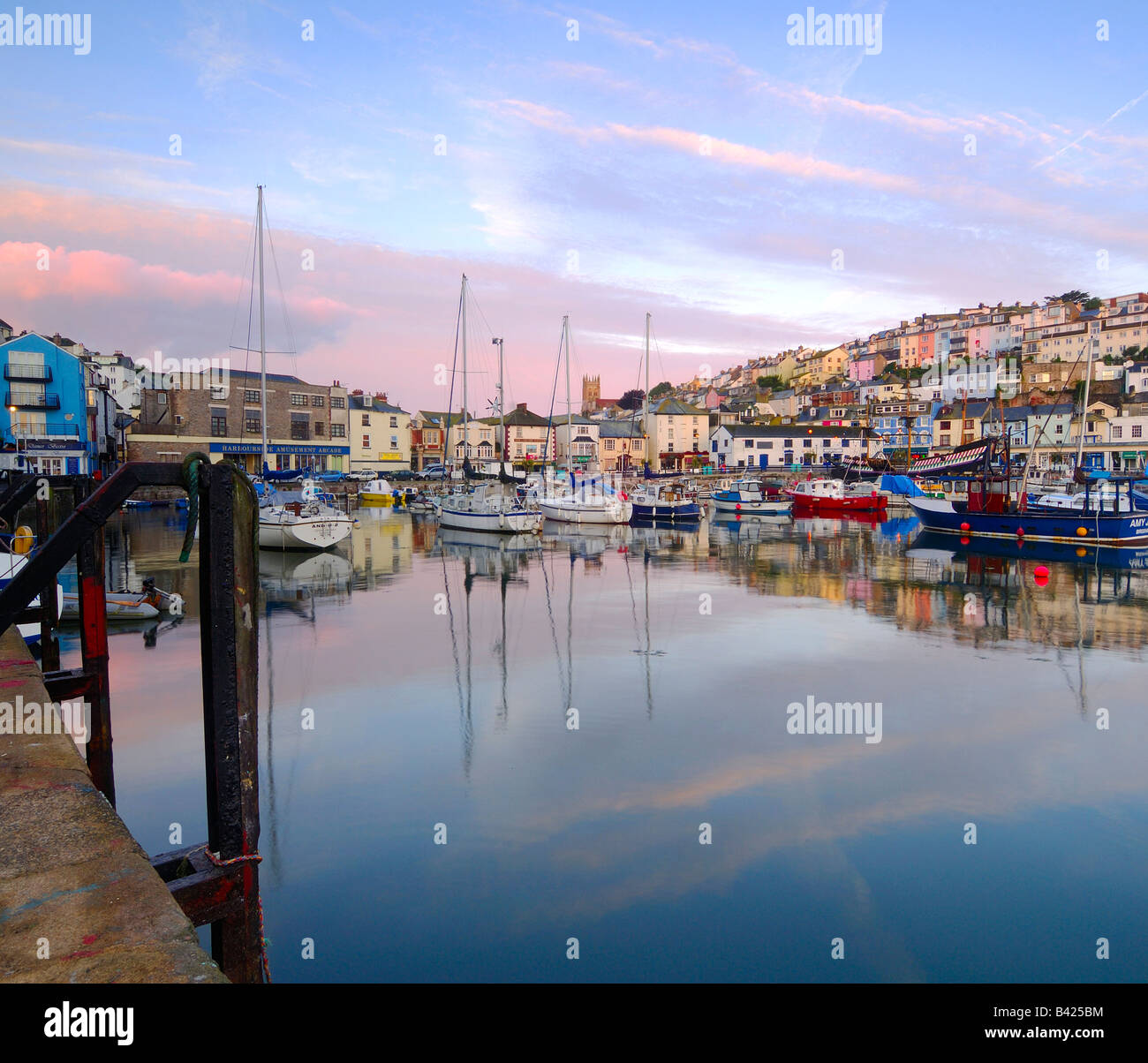 La piccola città di pescatori di Brixham sulla South Devon Coast all'alba con la bella mattina presto sky perfettamente riflessa Foto Stock