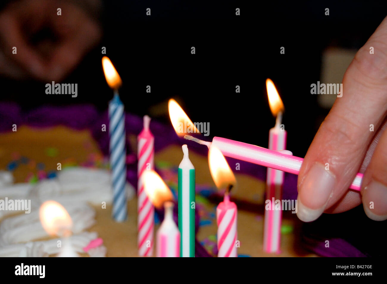 Femmina adulta mano con chiodi curati accendendo candele. Foto Stock