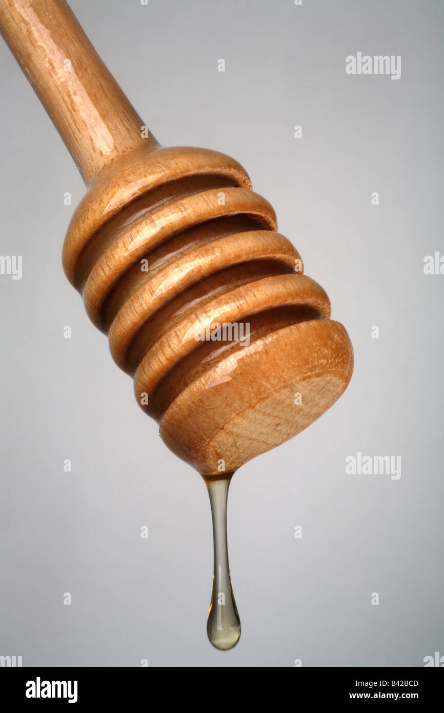 Il miele in legno server con miele di gocciolamento close up Foto Stock