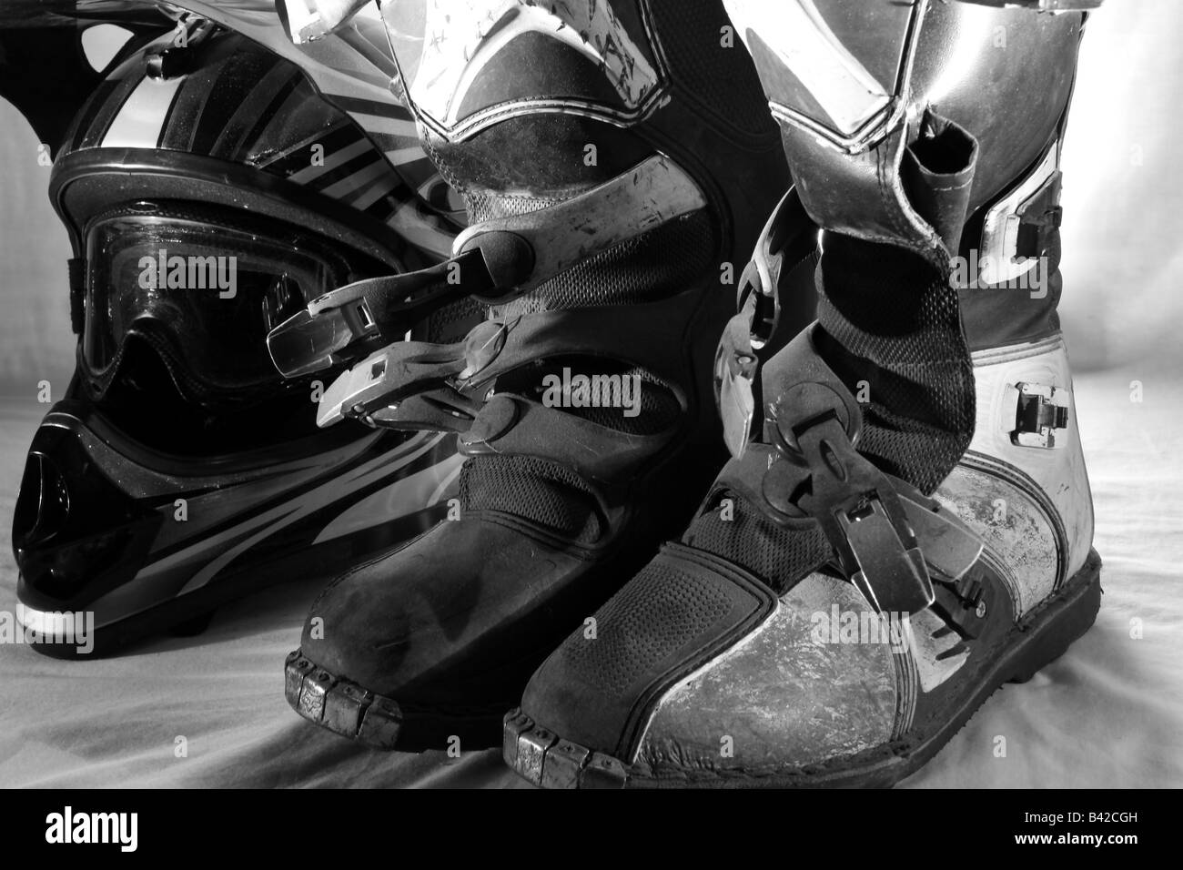 Una coppia di motocross fmx/stivali con un casco integrale e gli occhiali in officina/garage/seminterrato Foto Stock
